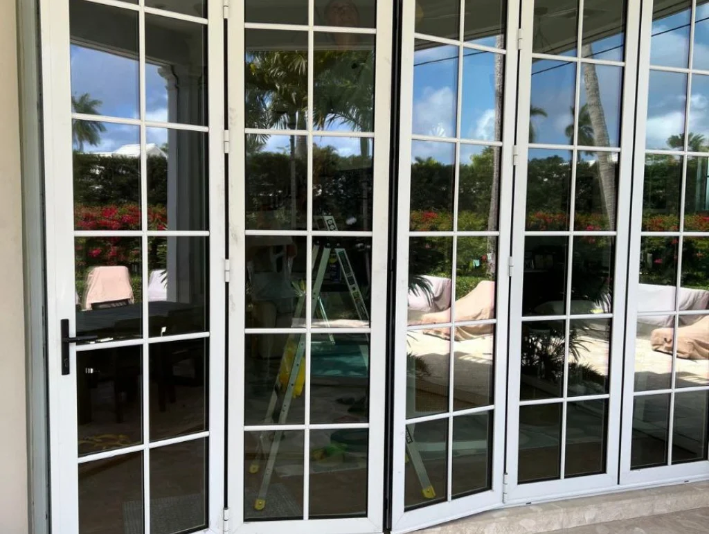 Grid French doors opening onto a patio and pool