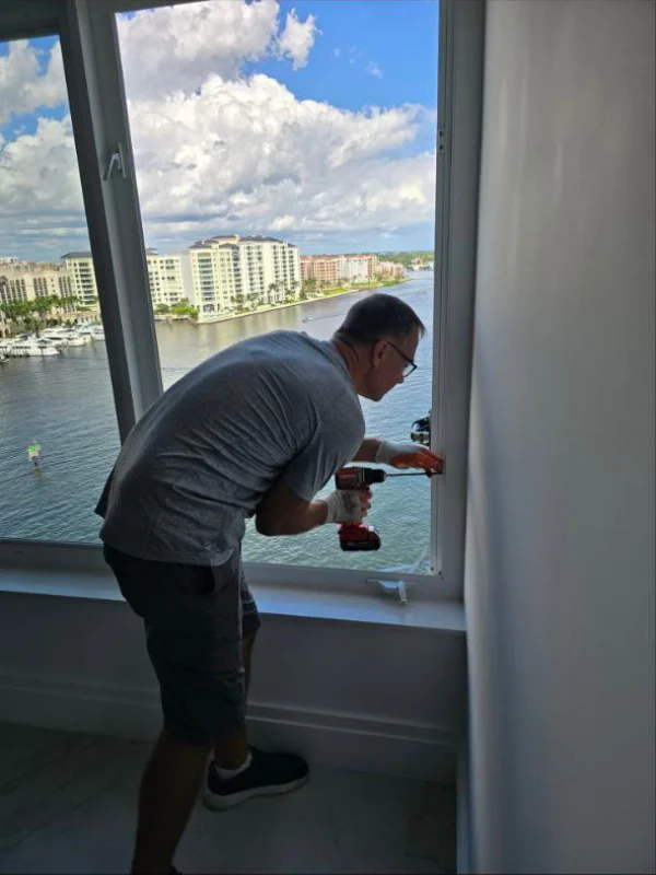 Technician kneeling to service a window track and frame