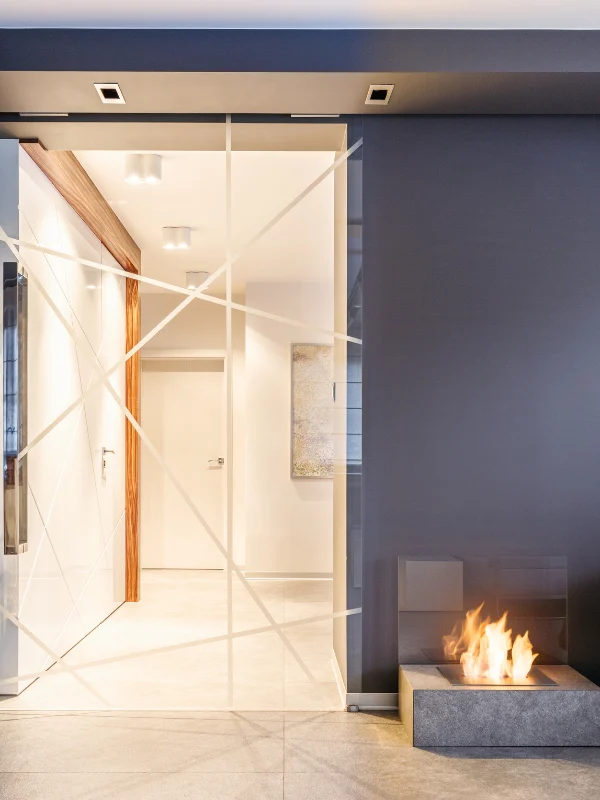 Interior hallway with a mirrored glass wall and fireplace