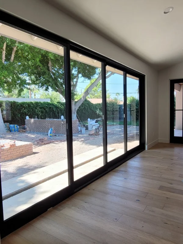 Wide black-framed sliding glass doors in an empty living room